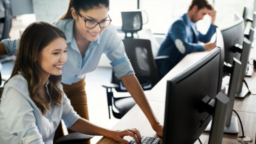 Coworkers Helping Each Other Out at an Office Desk